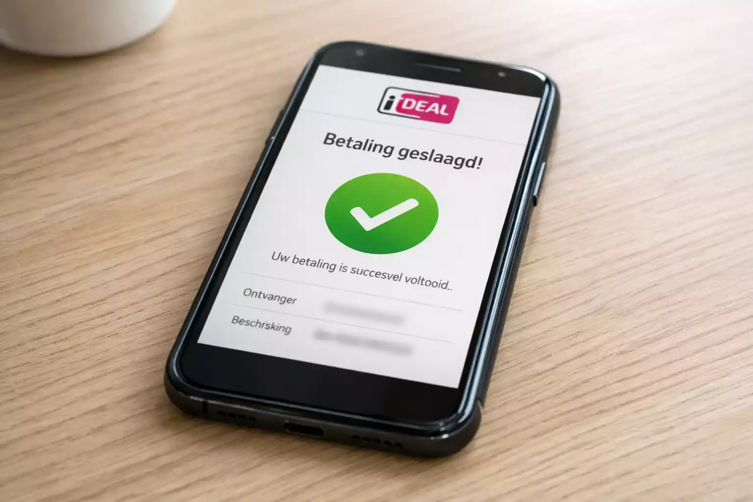 Smartphone met iDEAL betaling op houten tafel